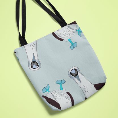 Canvas tote bag featuring a playful illustration of a blue-footed booby with vibrant blue feet and humorous text, displayed on a light green background. Perfect for bird lovers and fans of quirky designs.