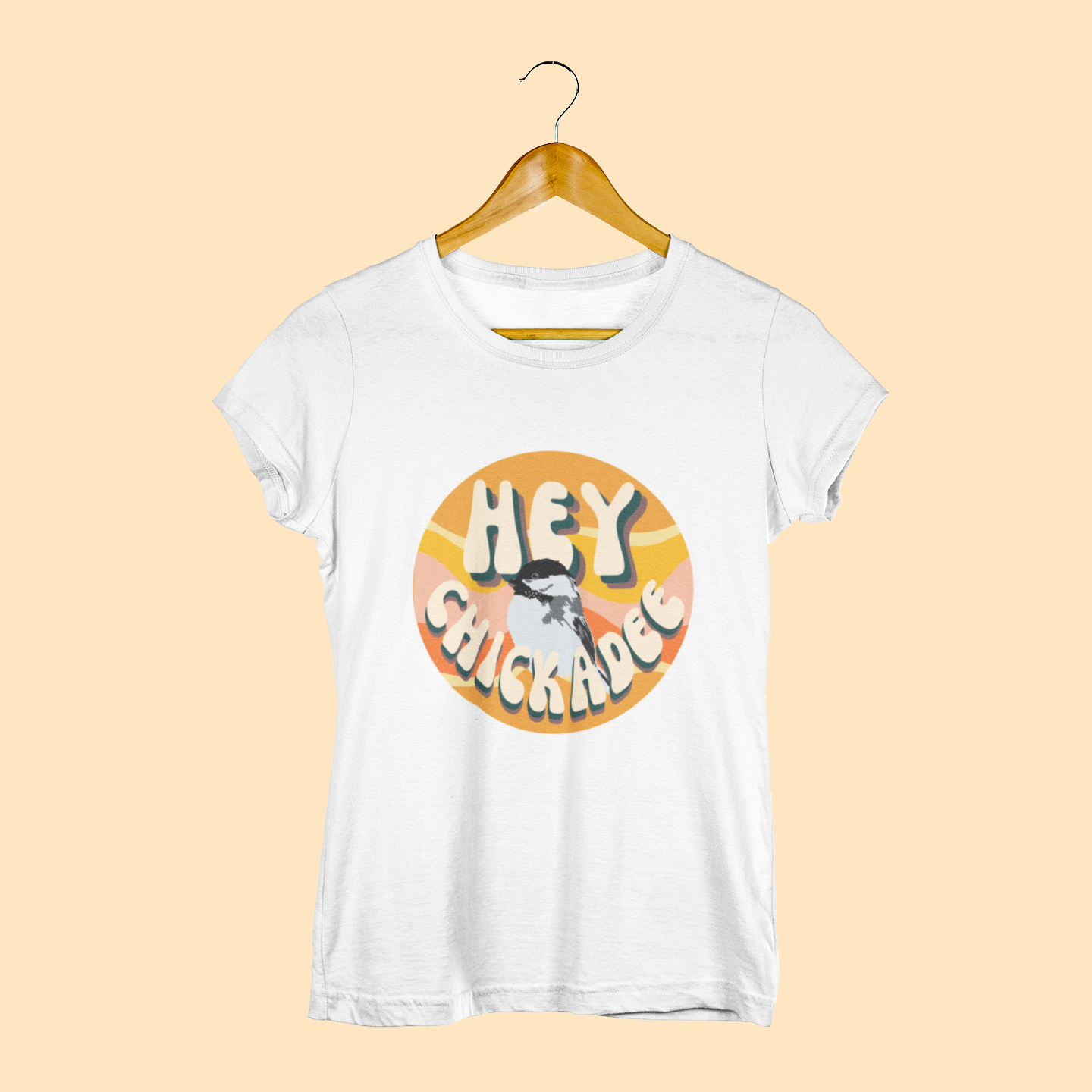 Vintage white t-shirt featuring the playful 'Hey Chickadee' design with retro-inspired typography and a chickadee illustration, displayed on a light yellow background