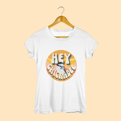 Vintage white t-shirt featuring the playful 'Hey Chickadee' design with retro-inspired typography and a chickadee illustration, displayed on a light yellow background