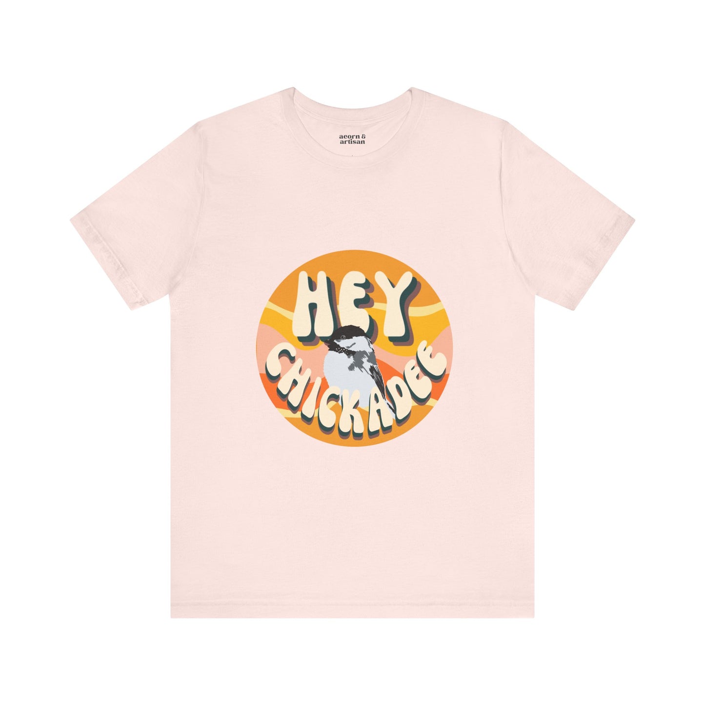 Front view of the 'Hey Chickadee' t-shirt in soft pink, showcasing the retro design and vibrant chickadee illustration on a clean white background