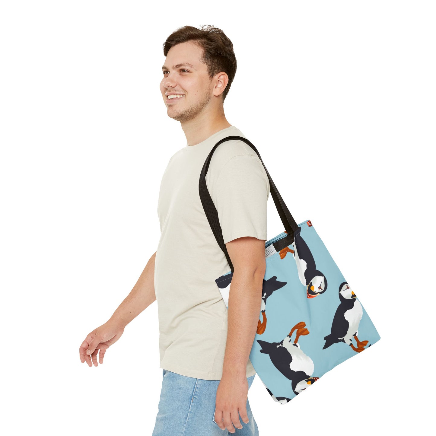 Canvas tote bag with a puffin bird pattern, carried by a model over their shoulder. Perfect for daily errands or as a stylish gift for bird lovers.