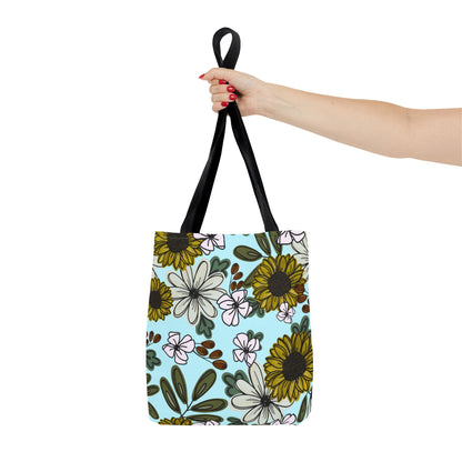 Stylish canvas tote bag featuring a sunflower and wildflower design with black handles, perfect for nature lovers and eco-conscious shoppers.