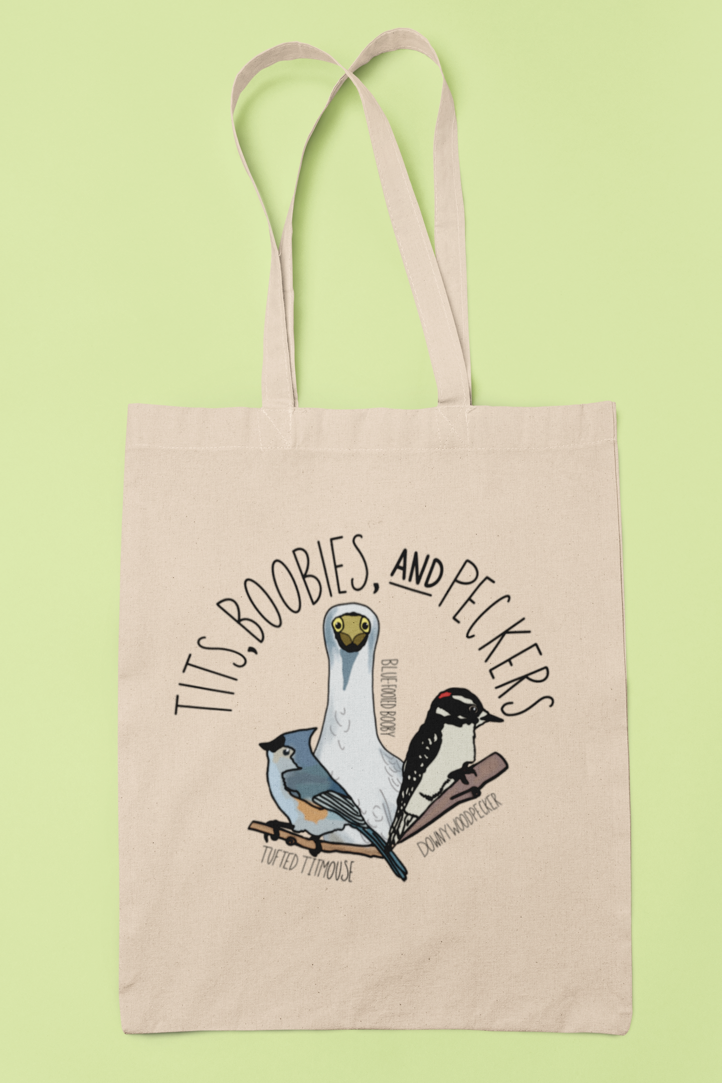 Canvas tote bag featuring the playful 'Tits, Boobies, and Peckers' design with colorful bird illustrations, displayed against a light background. Includes durable black handles.