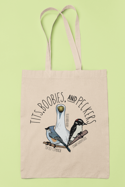 Canvas tote bag featuring the playful 'Tits, Boobies, and Peckers' design with colorful bird illustrations, displayed against a light background. Includes durable black handles.