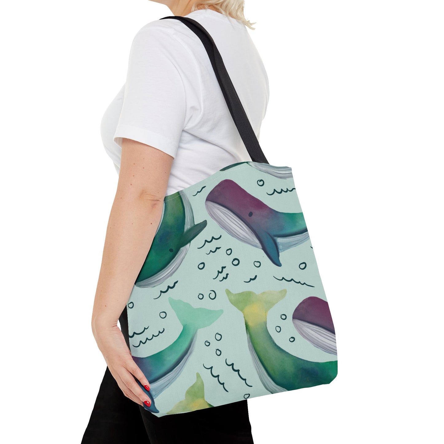 Close-up view of the 'Watercolor Whales' tote bag on a model, highlighting the intricate details of the whale pattern and durable black handles.