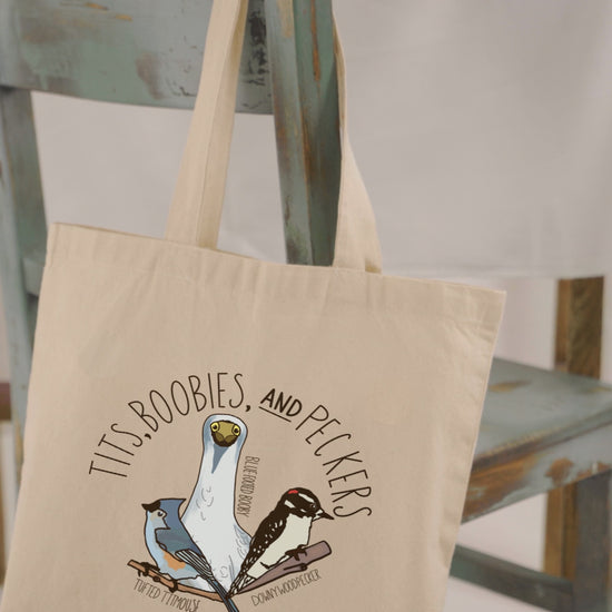 Video showcasing the 'Tits, Boobies, and Peckers' canvas tote bag. The video highlights the humorous bird-themed design with vibrant illustrations, durable handles, and spacious interior. Perfect for bird lovers and eco-conscious shoppers.