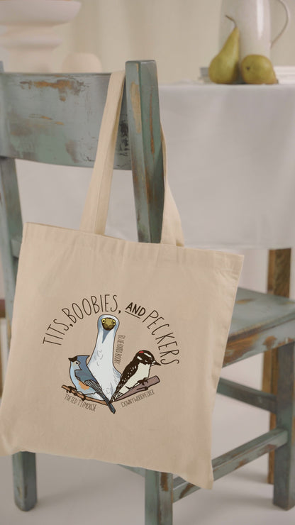 Video showcasing the 'Tits, Boobies, and Peckers' canvas tote bag. The video highlights the humorous bird-themed design with vibrant illustrations, durable handles, and spacious interior. Perfect for bird lovers and eco-conscious shoppers.